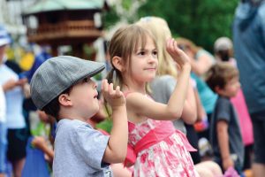Bennet Soricelli, 4, and his sister, Darcy Soricelli, 7, wave to people on a float as it passes by at the Berthoud Day parade.  John Gardner/ the Surveyor