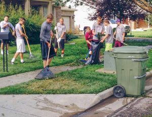 Members of the Berthoud High School football team cleanup a neighborhood after the July 14 hailstorm left debris scattered all over the streets and sidewalks.  John Hall / The Surveyor