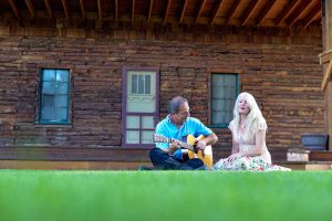 Butch Hause, left and his wife, Sarah Lincoln, play around in their backyard in front of the stage that has housed critically acclaimed musicians every August as part of the annual Farm Concert. John Gardner / The Surveyor