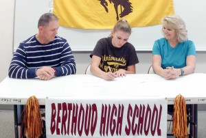 Berthoud High School’s Kiah Leonard, center, with her mother, Kristi Leonard, right, and father, Dale Leonard, left, signs her letter of intent to join the University of Wyoming’s cross country team and attend as a student next fall. John Hall / The Surveyor