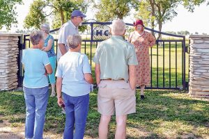 Pauli Driver-Smith tells Backroads travelers about the Highlandlake Cemetery gate at the Highland Cemetery on July 11. The gate was a relatively recent addition to the historical landmark. May Soricelli / The Surveyor