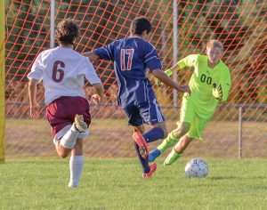 Berthoud goal keeper Hunter Hursey charges a Northridge opponent to save a goal in the first half of the Sept. 1 game at Berthoud High School. John Gardner / The Surveyor