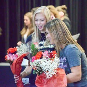 Alyssa Strong, left, and Josie Spitz receive flowers from family after signing their letters of intent on Nov. 11 in the BHS commons. John Gardner / The Surveyor
