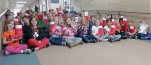 Berthoud Elementary School first and second graders pose for a photo in the school’s hallway to show off their Christmas stockings that they put together for veterans through the Soldiers’ Angels program, with help from the Berthoud American Legion Auxiliary Justin Bauer Memorial Post 67, which provides stockings for U.S. military veterans. The Berthoud El students provided over 100 stockings for veterans in need this holiday season. Katie Harris / The Surveyor