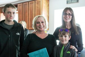 Robin Fancis smiles for a photo with her two sons, Joshua, 15, left, and Caleb, 13, right, and Kim Land of Grace Place Church, during a home dedication on Jan. 23. Angie Purdy / The Surveyor 