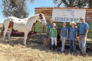 Guy and Kaarin Scoma, founders of Guided Hope in west Berthoud, run the nonprofit working ranch that helps people dealing with grief and loss or other issues. Guy and Kaarin operate the ranch with the help of their four children. From left to right, Scout the horse, Kaarin Scoma, Jessica, 10, Kira, 12, Tucker, 14, and Guy Scoma. The Scomas also have a 20-year-old daughter, Katelyn, who isn’t pictured. photo by Katie Harris / The Surveyor