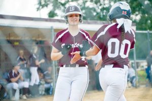 Berthoud’s Morgan Schachterle (24) is congratulated by teammate Sotera Dageenakis as she crosses home plate during the home opener against Roosevelt on Aug. 25. The Spartans won the game 12-2. John Gardner / The Surveyor